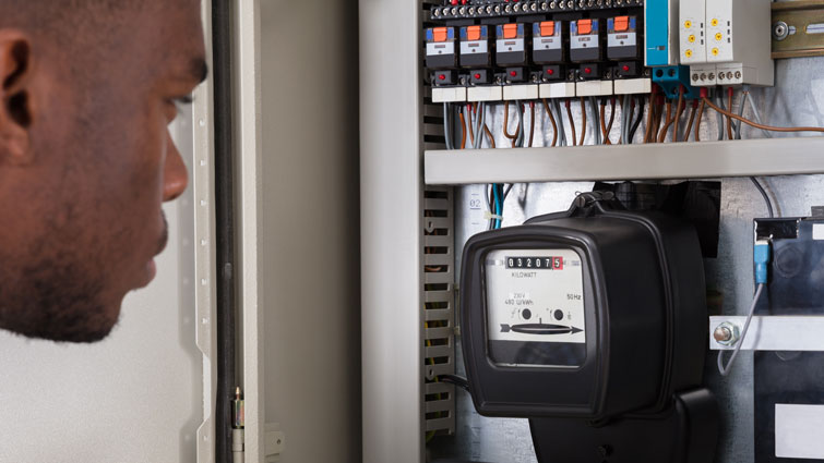 This is an image of a man looking at a meter
