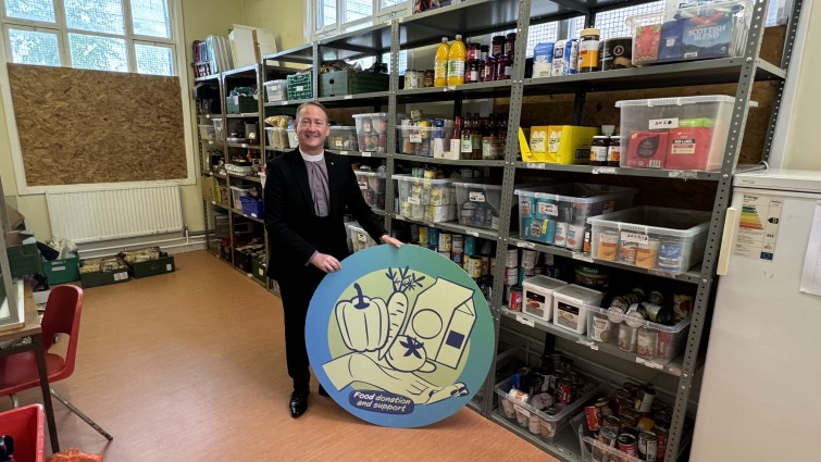 This image shows a member of Hamilton Churches drop in centre with the donations he has received from the community wish list