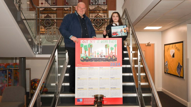 Councillor Davie McLachlan, Chair of the Road Safety Forum, with Ruby Coia and her winning design for the Road Safety Calendar Competition, 2024.