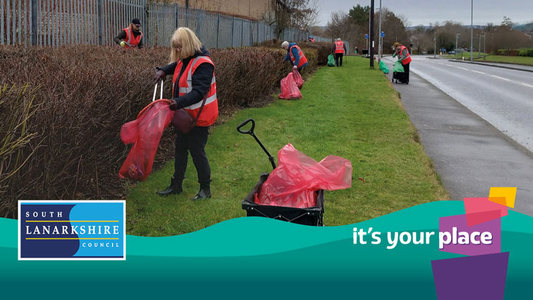 Litter picking along roadside with Its Your Place graphic