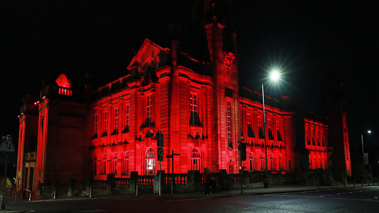 Photo shows Hamilton Town House lit up red to remember everyone who has lost their life in armed conflict
