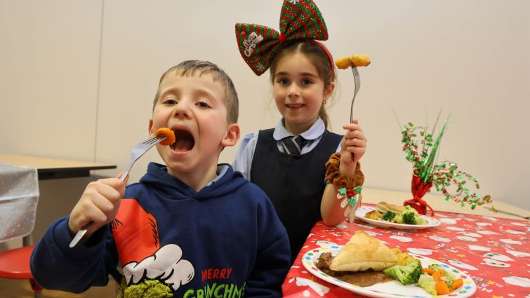 This image shows two pupils from Bankhead Primary School enjoying their Christmas lunch