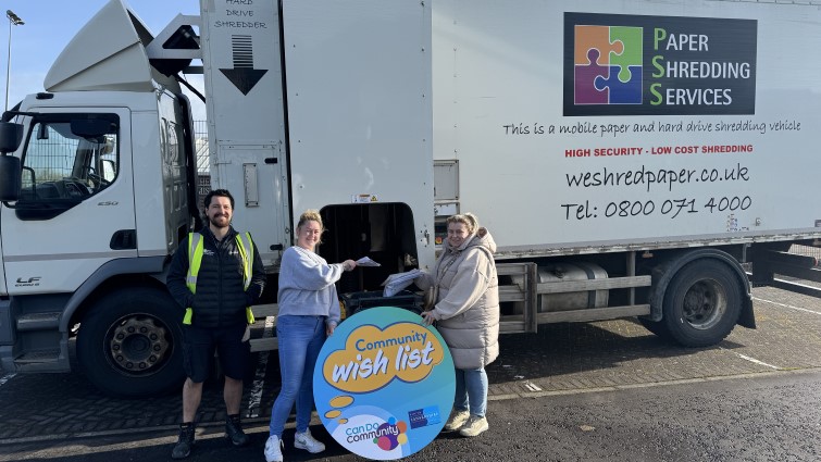 Paper Shredding company driver David Wilson, and Nicole Kane and Lizzie McDonald of the highbacks group are standing together in front of the shredding truck.