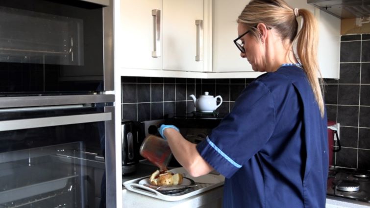This image shows a Care at Home worker preparing some food