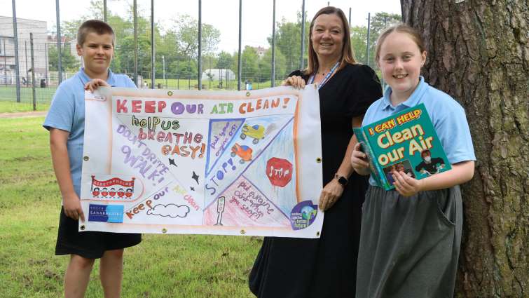 This image shows Kirktonholme Primary head teacher Linda Wright with two pupils, including Devon who won an anti-engine idling poster competition run by the council