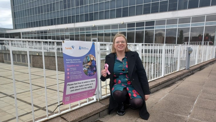 This image shows Councillor Lynsey Hamilton outside SLC HQ where ribbons can be placed in memory of babies who lost their lives too soon 