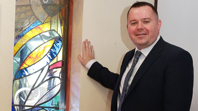 This photo shows Council Leader, councillor Joe Fagan admiring the stained glass window in close up.