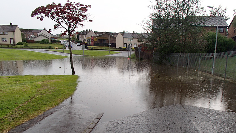A flooded road in a residential area.