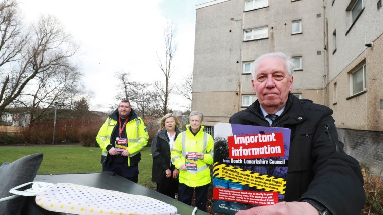 fly tipping leaflet being held by Councillor Robert Brown, the chair of the council’s Community and Enterprise Resources Committee