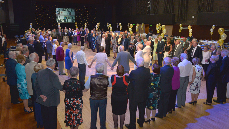 This image shows a group shot of couples at a previous Golden Wedding event