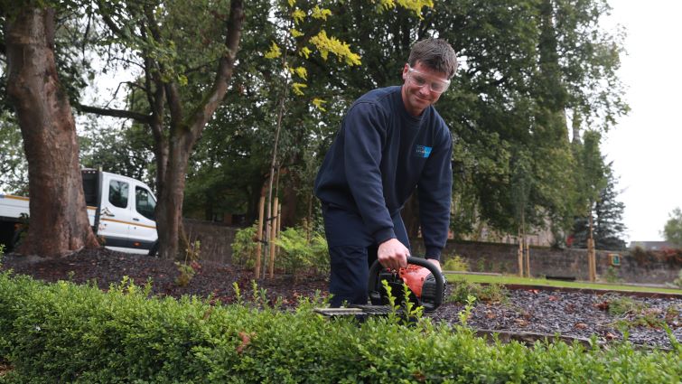 This image shows a council worker using a chainsaw on a tree following a storm