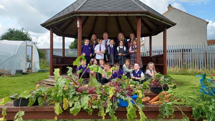 pupils and teachers at Hareleeshill Primary School with some of their vegetable harvest