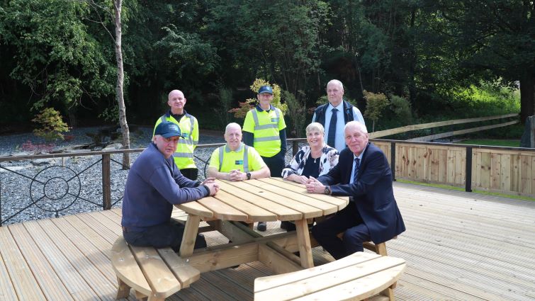 Chair of the Clydesdale Area Committee Councillor Catherine McClymont and Chair of the Community and Enterprise Resources Committee, Councillor Robert Brown, sitting with Lanark Loch staff at the newly refurbished decking area