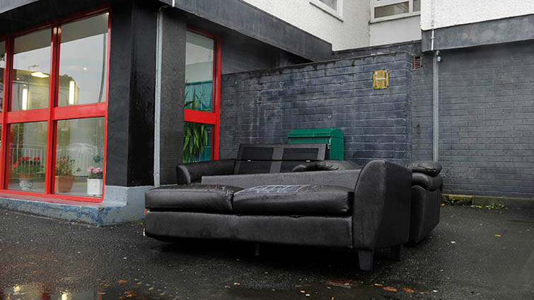 A discarded couch sits outside a block of high-rise flats in South Lanarkshire