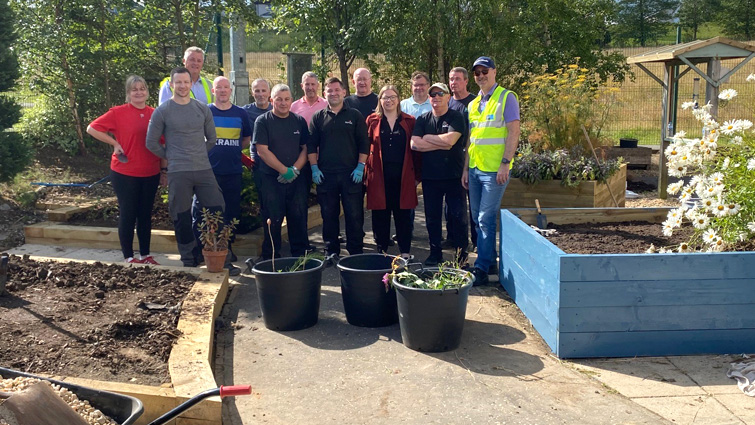 Volunteers from Rutherglen High School's PPP partners gather during their day working to help restore the school garden.