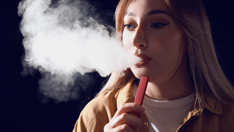 This image shows a young person using a single use vape