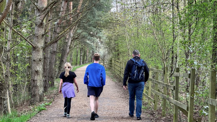 This image shows the back of three people walking in Chatelherault Country Park