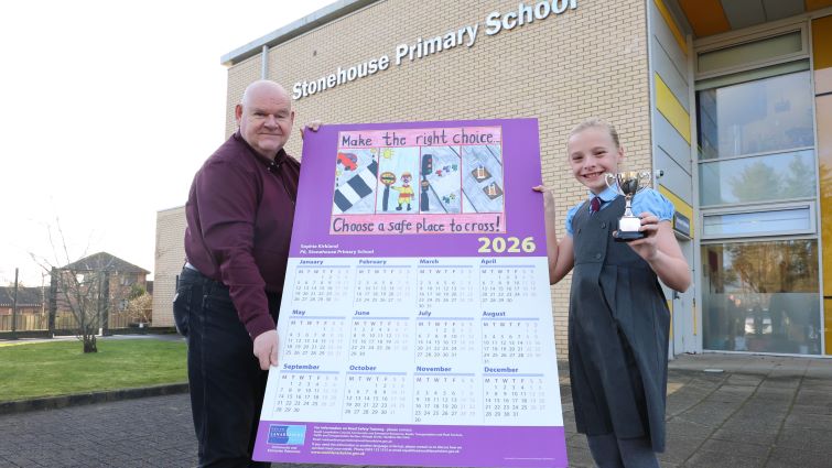 This image shows Councillor Davie McLachlan with the winner of the council's annual road safety calendar competition, Sophie Kirkland