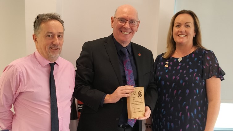 This image shows chief exec Cleland Sneddon being presented with the Martin Keeley award for Outstanding Contribution to Environmental Health 2023
