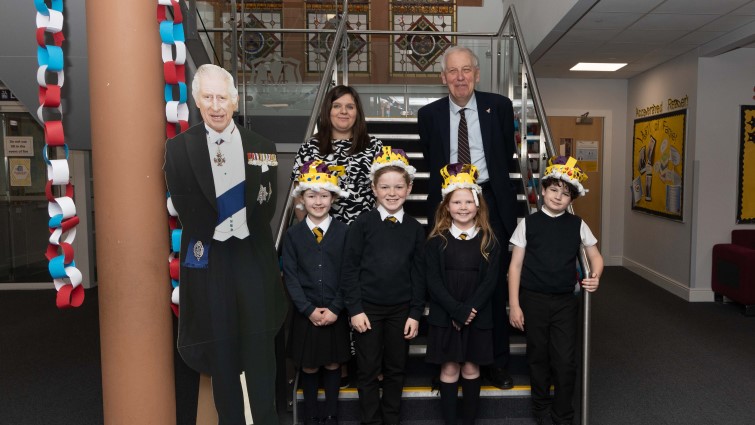This image shows Muiredge PS pupils, the head teacher, Councillor Robert Brown and a cardboard cut out of King Charles III following a special coronation themed lunch at the school
