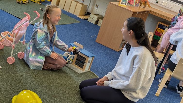 This image shows a member of staff with a pupil at Rigside Nursery following a settling in session following a fire at the old nursery building