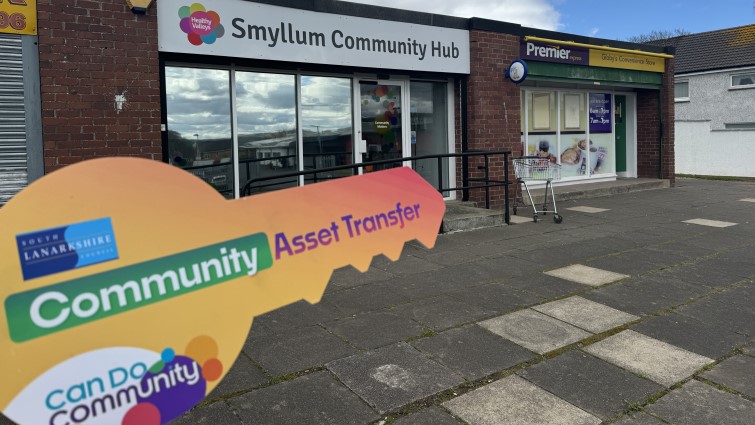 This shows the exterior of Smyllum community hub with a prop saying community asset transfer in the shape of a key in the foreground
