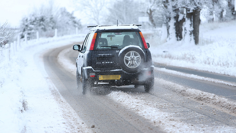 A car makes its way down a South Lanarkshire road following snow