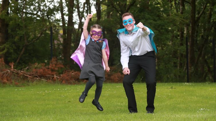 Five-year-old Ellie and Councillor Gavin Keatt jump in the air, wearing eye masks and capes to promote our superhero campaign.