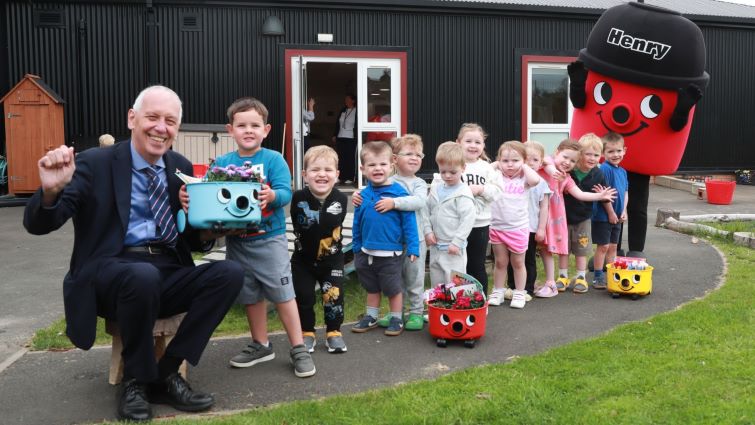 Councillor Robert Brown with children at Woodhill Nursery, Blackwood, and Henry the Mascot (for Henry vacuum cleaners).